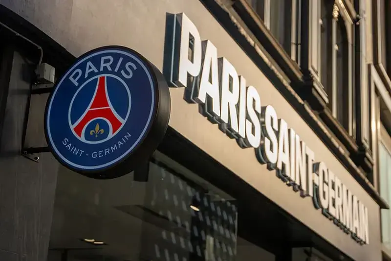 Illuminated PSG (Paris Saint-Germain) signage mounted on a storefront, showcasing Premier Bond's high-quality signage solutions for businesses.